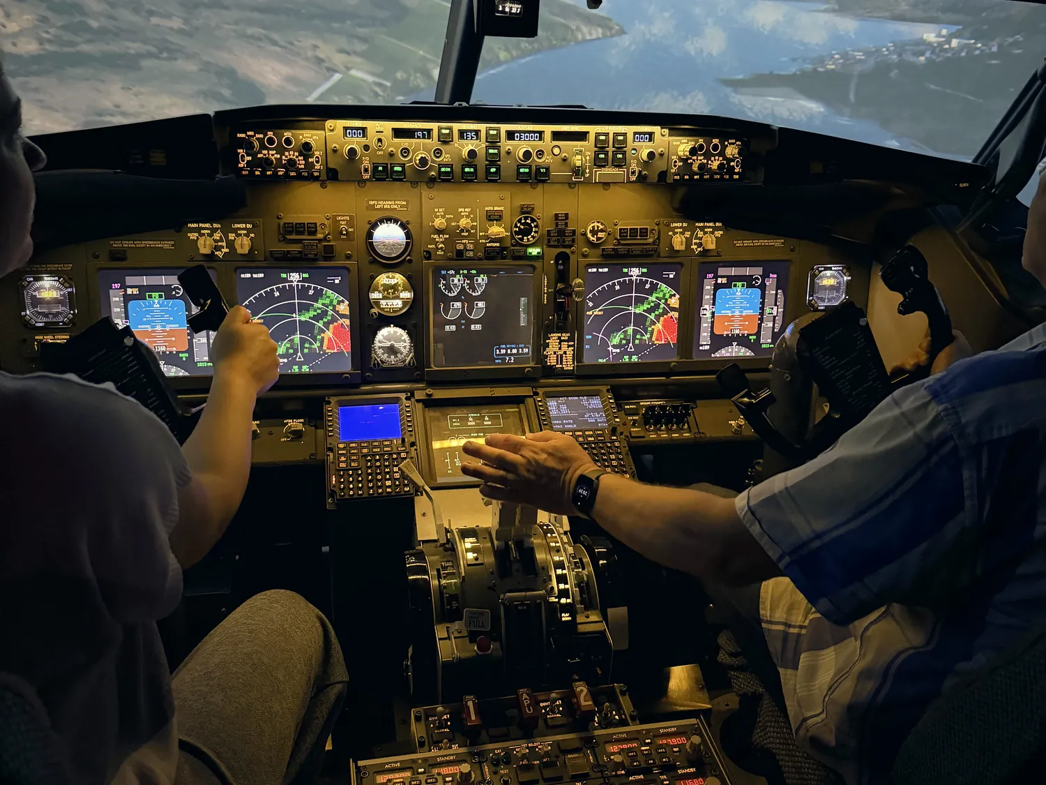 Инструктор показывает гостю органы управления в кабине Boeing 737 NG