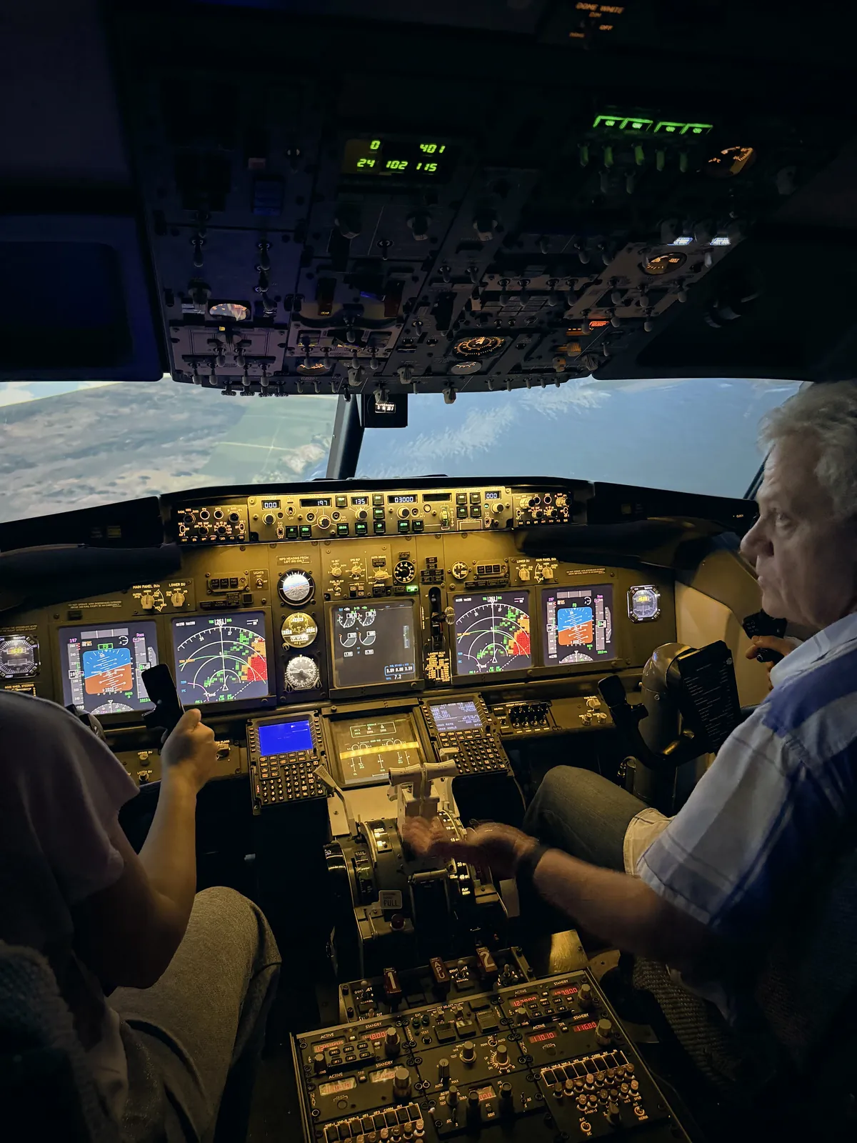 Инструктор и гость в кабине авиасимулятора Boeing 737 NG при заходе в облачности