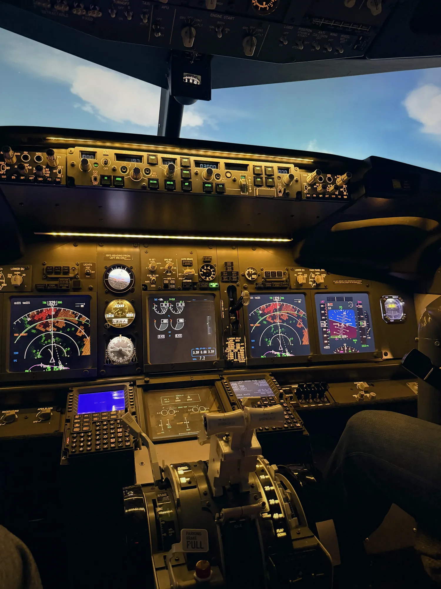 Приборная панель Boeing 737 NG в авиатренажёре: пилотажный и навигационный дисплеи, панель автопилота, рычаги управления двигателями